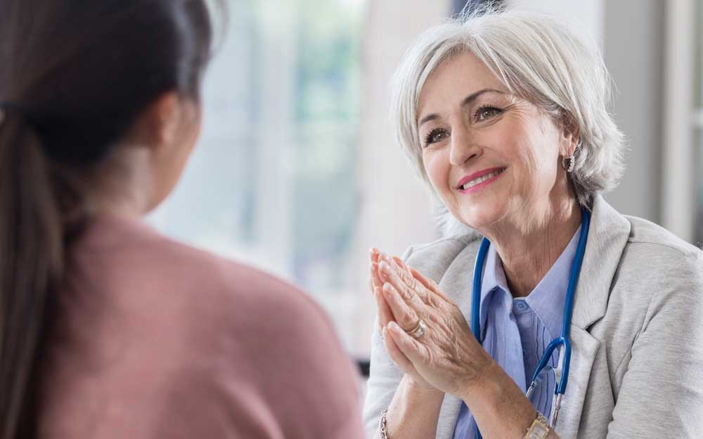 A clinician speaks with her patient