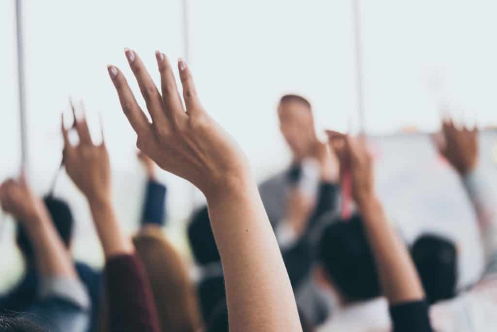 Hands raised in a seminar