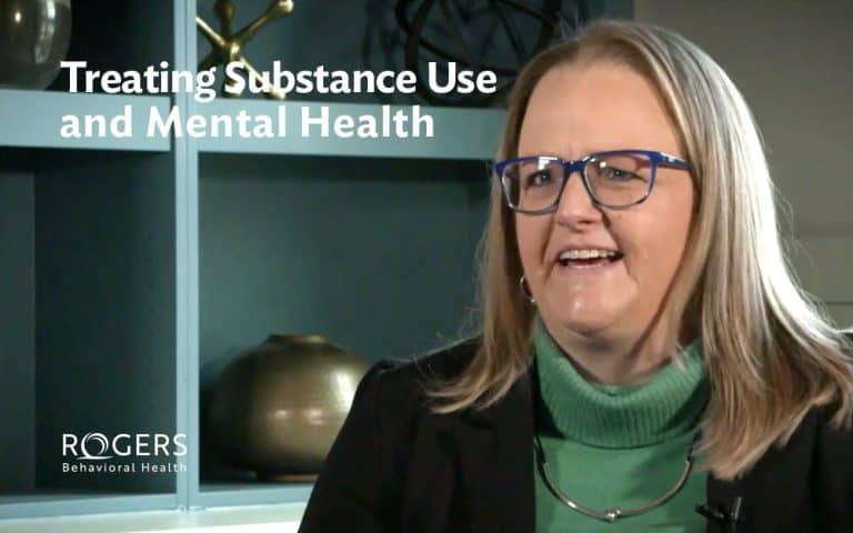 Woman in glasses wearing green and black with glasses. She is smiling. Text says Treating Substance Use and Mental Health