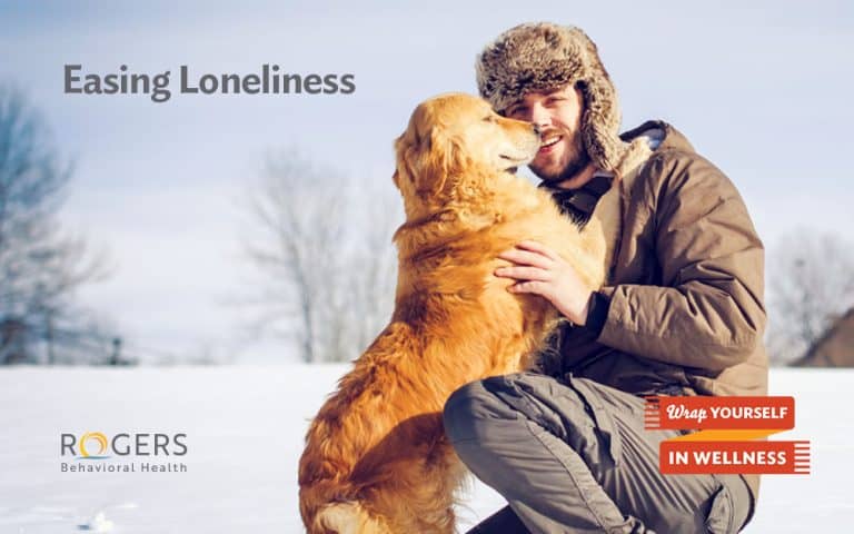 The image features a smiling man playing with his dog in winter. Text says, "Easing Loneliness"