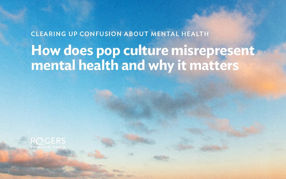The image shows a vibrant sky filled with clouds in various shades of pink, orange, and gray against a bright blue background, Overlaid on the image is text in white: CLEARING UP CONFUSION ABOUT MENTAL HEALTH How does pop culture misrepresent mental health and why it matters