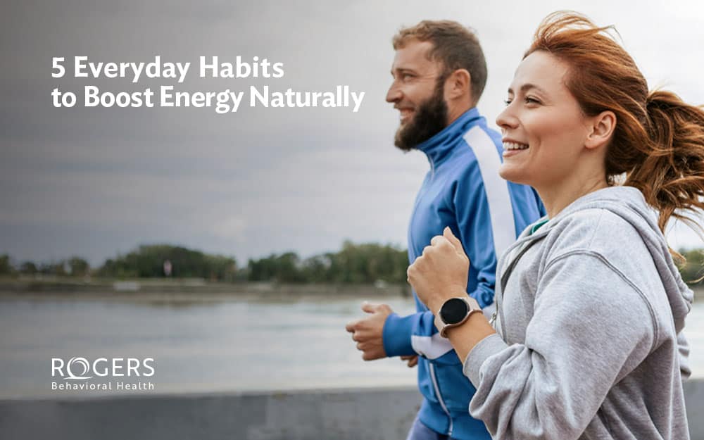 The image shows a man and a woman jogging alongside a waterfront as part of their routine to boost energy daily. Transcribed Text: 5 Everyday Habits to Boost Energy Naturally