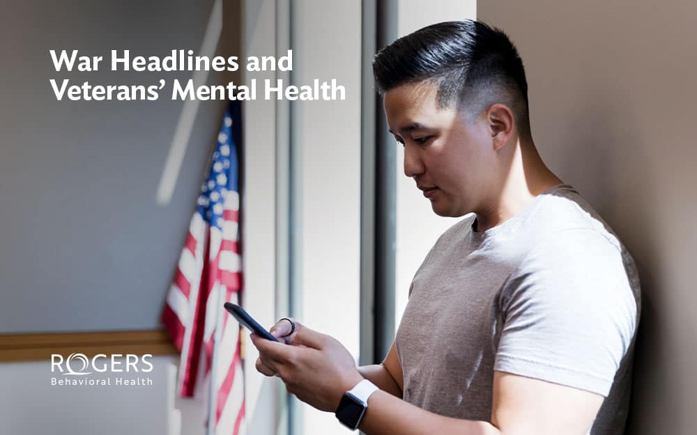 Young man who is a veteran and concerned reading updates about the war against Iran. Text says: War Headlines and Veteran's Mental Health