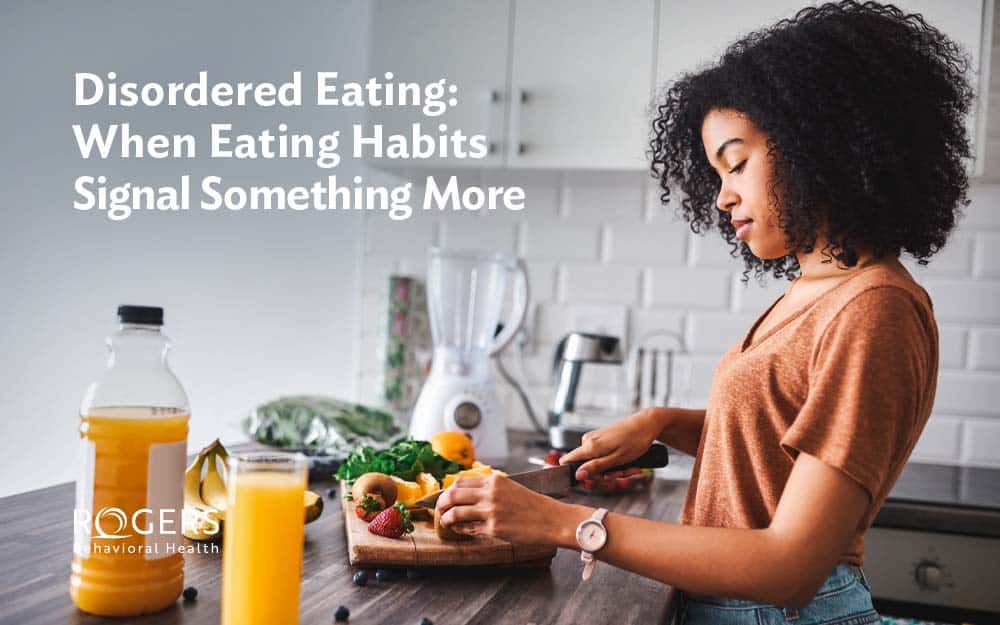 Image shows a young woman in the kitchen preparing a snack consisting of limited foods due to her disordered eating.