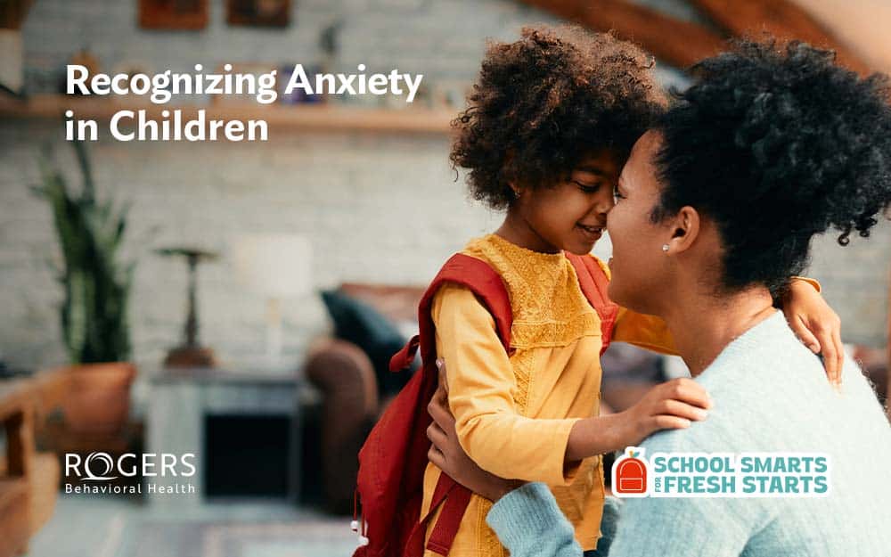 Image shows a mom hugging her anxious daughter before school. Text says Recognizing Anxiety in Children