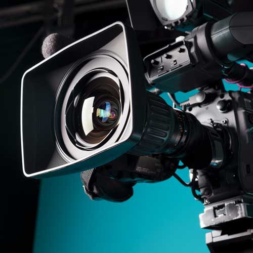 A close up of a news camera on a blue background