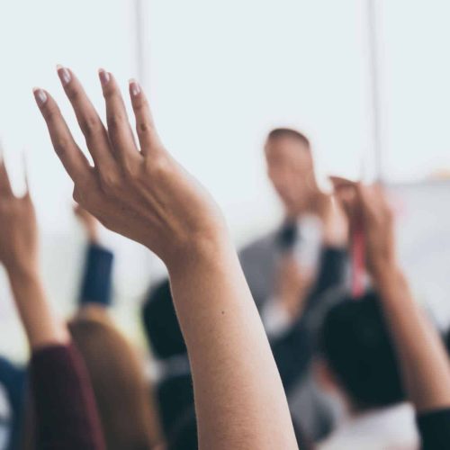 Hands raised in a seminar